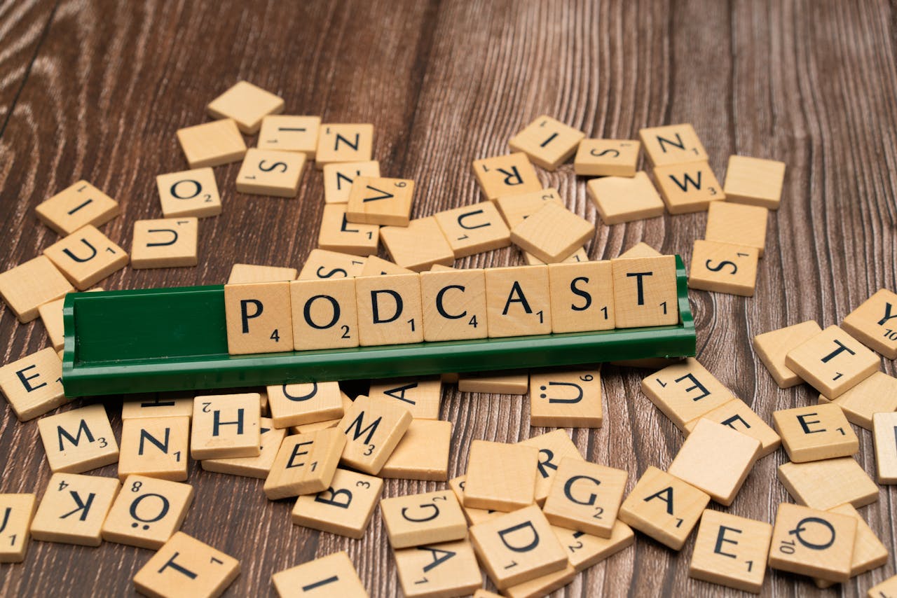 cta-bg Wooden letter tiles on a board spelling the word Podcast, symbolizing digital media and creativity.