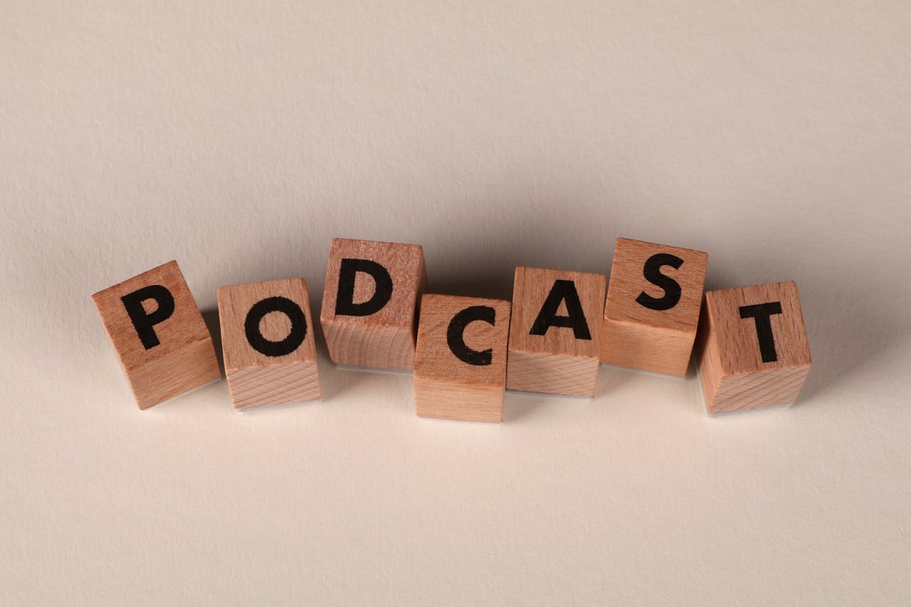 home-hero-bg Wooden blocks spelling PODCAST on a neutral background, symbolizing audio content creation.