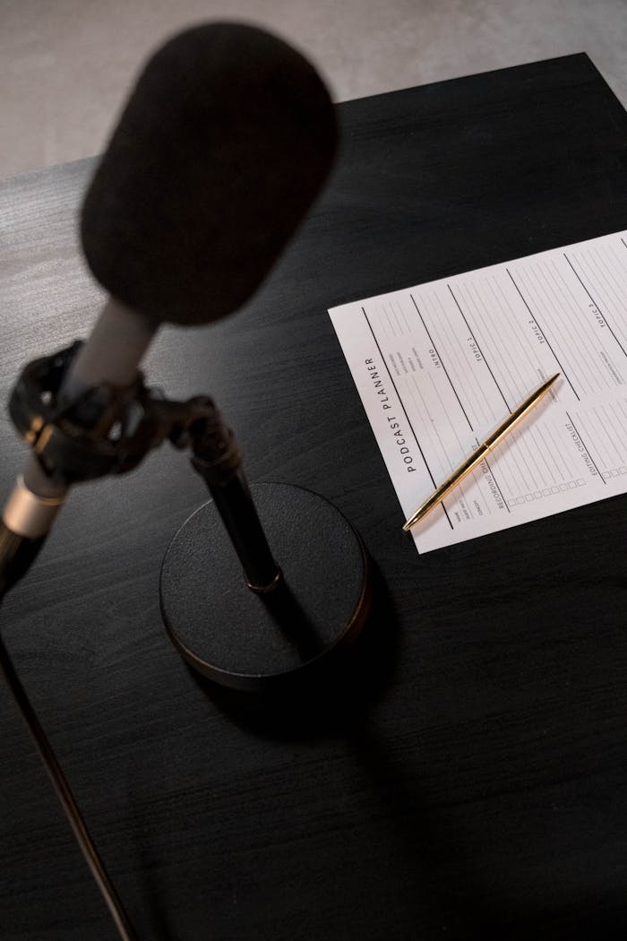 home-services-02 A desk setup featuring a microphone and a podcast planning sheet, perfect for audio recording sessions.